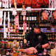 Man surrounded by ham hocks in Spanish grocery